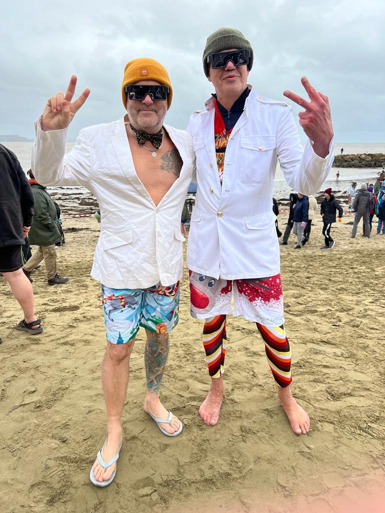 picture of two people dressed in fancy dress ready to go for a swim in Lyme Regis, Dorset, wearing 2024 glasses.